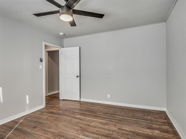 empty room with ceiling fan and dark hardwood / wood-style floors