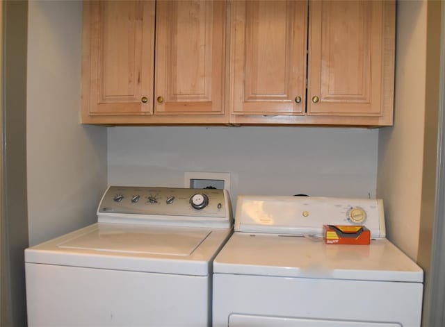 laundry area featuring washer and dryer and cabinets