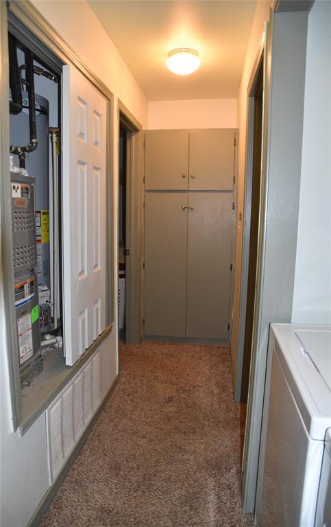 hall featuring washer / dryer, gas water heater, and carpet flooring