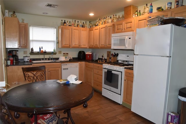 kitchen with dark hardwood / wood-style flooring, sink, light brown cabinets, and white appliances