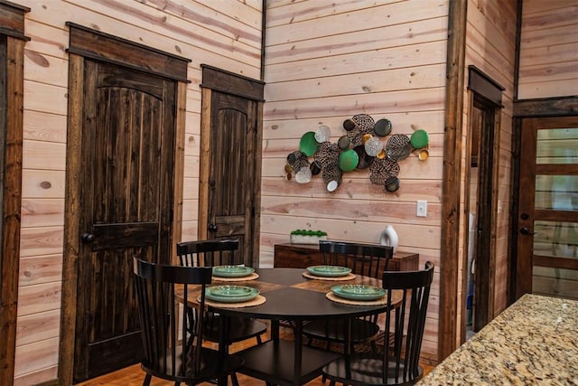 dining space featuring wooden walls