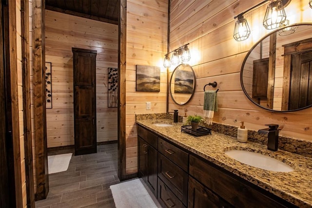 bathroom with hardwood / wood-style flooring, vanity, and wood walls