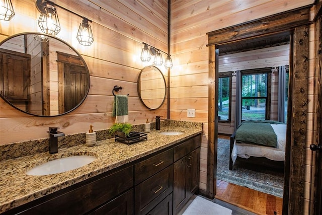 bathroom with vanity, hardwood / wood-style floors, and wooden walls