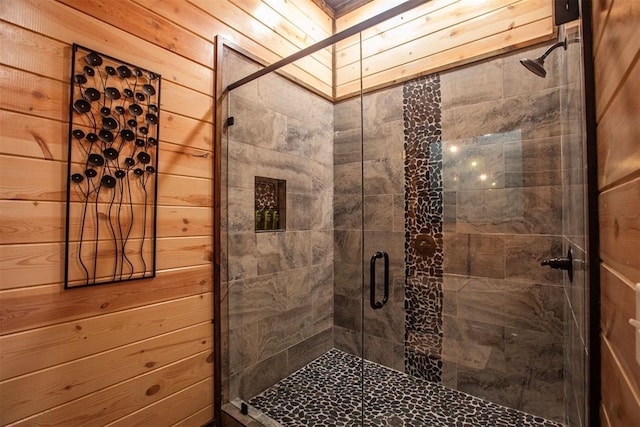 bathroom featuring a shower with door and wooden walls