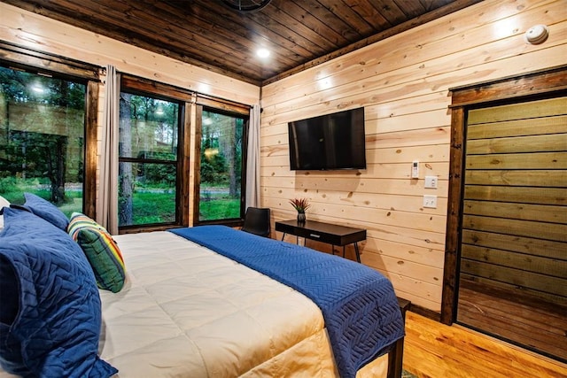 bedroom featuring wood walls, light wood-type flooring, multiple windows, and wooden ceiling