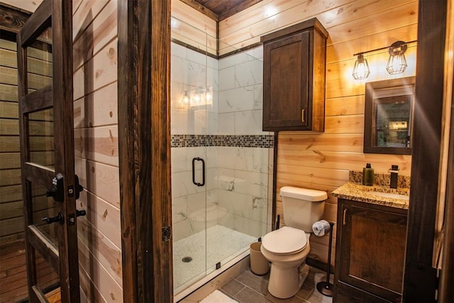 bathroom with vanity, toilet, an enclosed shower, and wood walls