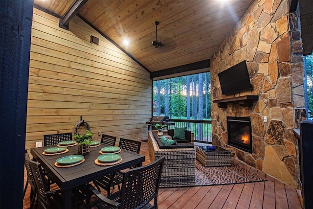 wooden deck with area for grilling and an outdoor living space with a fireplace