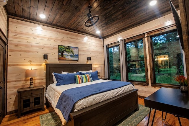 bedroom with recessed lighting, wooden ceiling, wood finished floors, and wooden walls