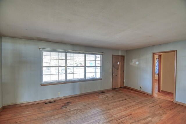 empty room with light hardwood / wood-style flooring