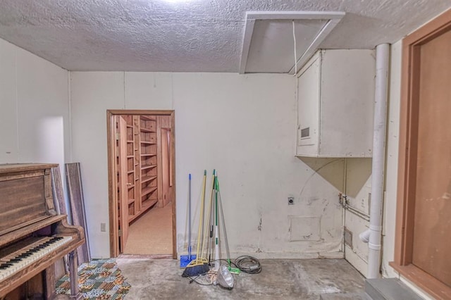 misc room featuring a textured ceiling and concrete flooring