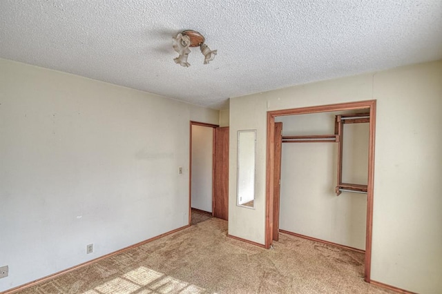 unfurnished bedroom with a textured ceiling, a closet, and light carpet