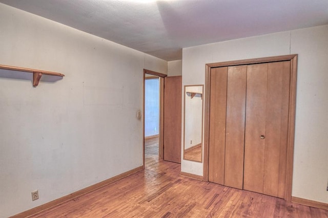 unfurnished bedroom with light hardwood / wood-style floors and a closet