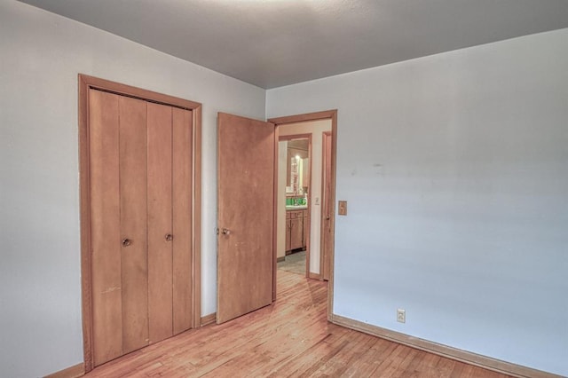 unfurnished bedroom featuring light wood-type flooring and a closet