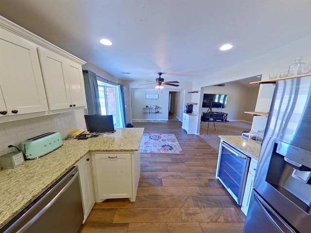 kitchen featuring white cabinets, appliances with stainless steel finishes, dark hardwood / wood-style flooring, backsplash, and ceiling fan