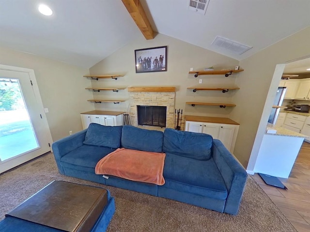 living room with light colored carpet, a stone fireplace, and vaulted ceiling with beams