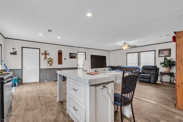 kitchen with ceiling fan, light hardwood / wood-style floors, white cabinetry, and range with electric stovetop