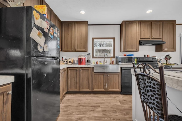 kitchen featuring sink, light hardwood / wood-style flooring, and black appliances