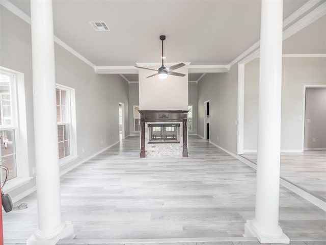 unfurnished living room featuring light hardwood / wood-style floors, ornamental molding, and decorative columns