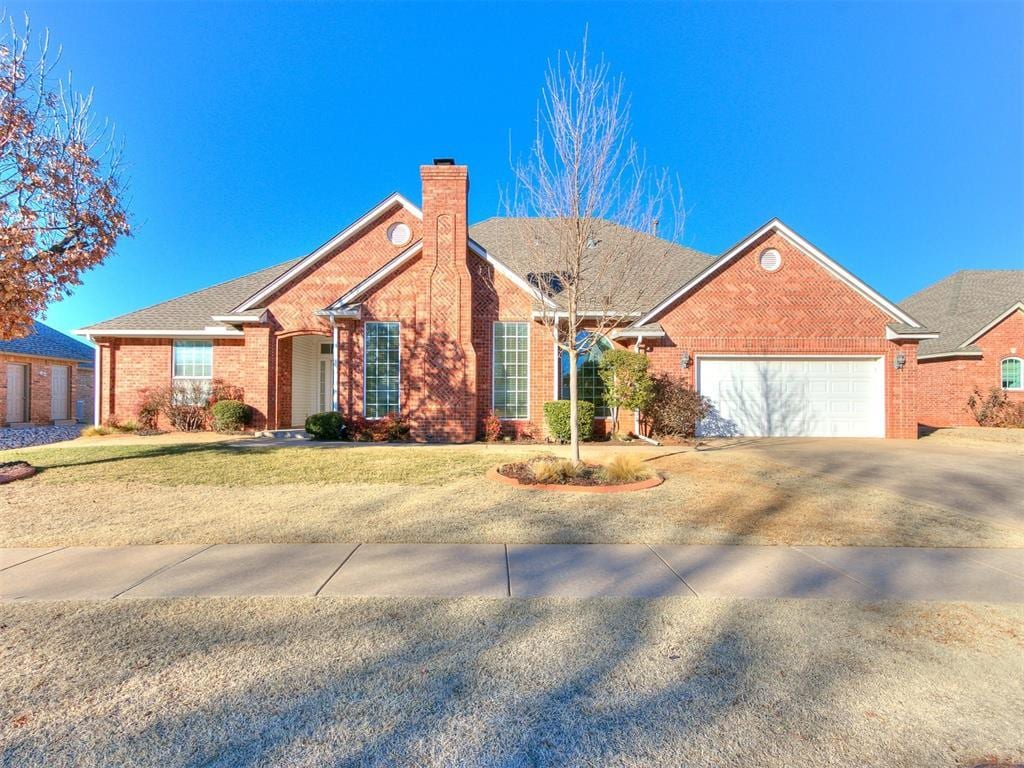 ranch-style house featuring a garage and a front lawn