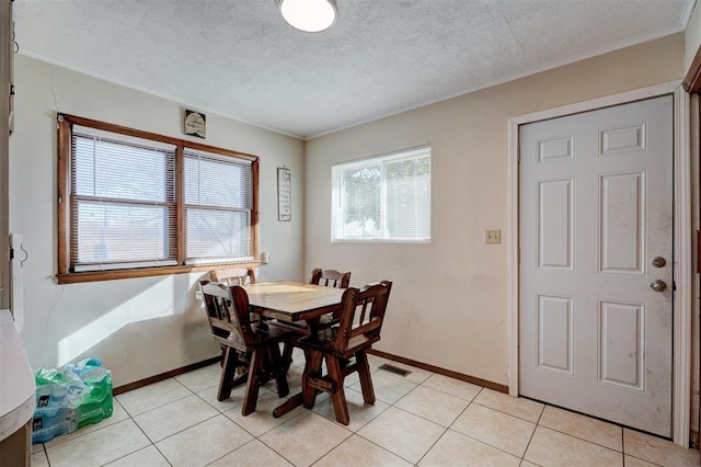 tiled dining area featuring a textured ceiling