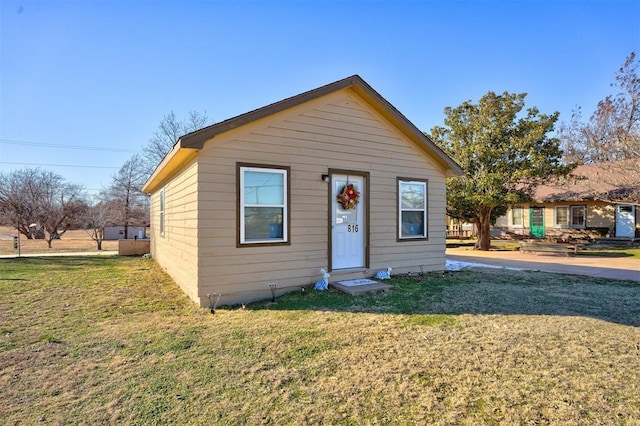 bungalow-style house featuring a front lawn