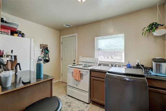 kitchen with light tile patterned floors, sink, and white appliances