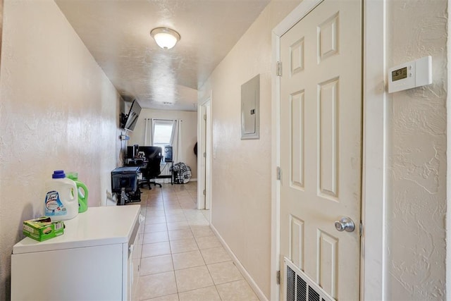 hall featuring light tile patterned floors and electric panel