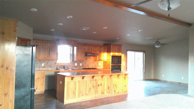 kitchen with ceiling fan, tasteful backsplash, a center island, black appliances, and beamed ceiling