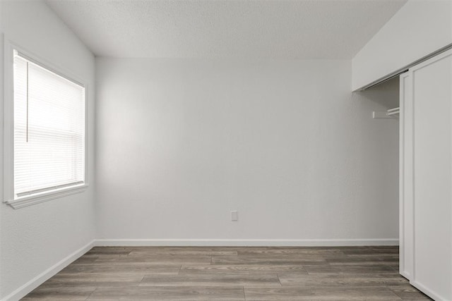 interior space with a textured ceiling and wood-type flooring