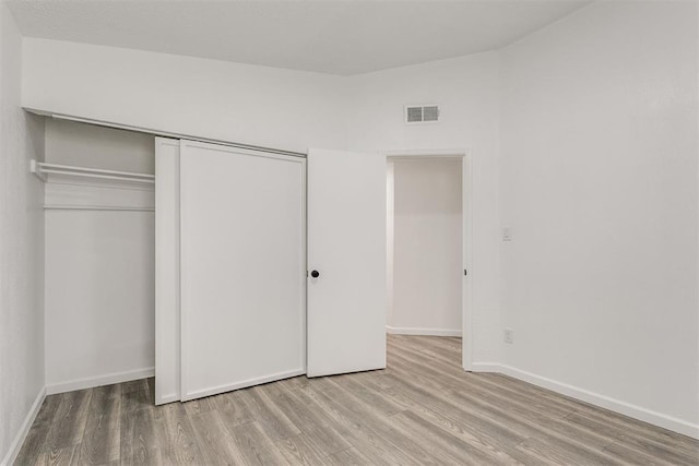 unfurnished bedroom with a closet and light hardwood / wood-style flooring