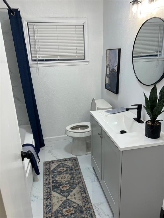 full bathroom featuring toilet, shower / bath combo, and vanity