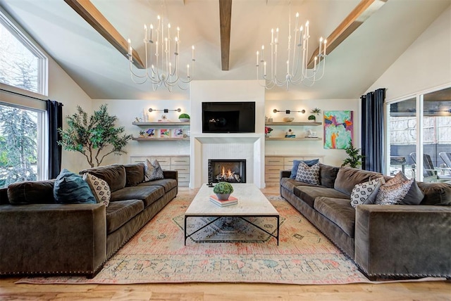 living room with an inviting chandelier and lofted ceiling with beams