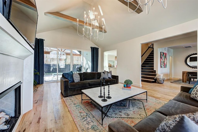 living room with vaulted ceiling with beams, hardwood / wood-style floors, and a notable chandelier