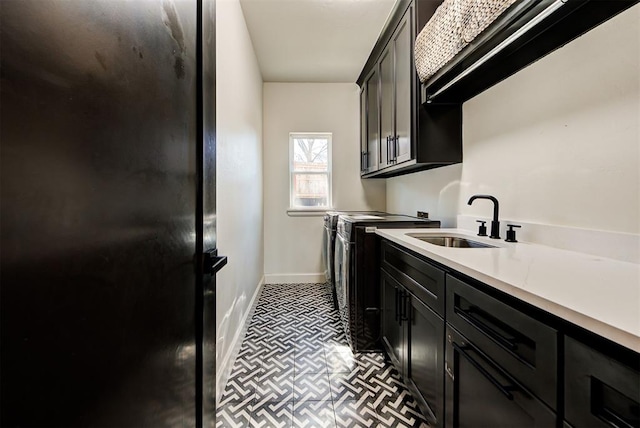 laundry area with cabinets, washing machine and dryer, and sink