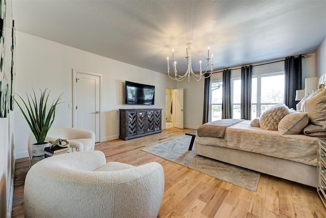 bedroom with light hardwood / wood-style floors and a notable chandelier