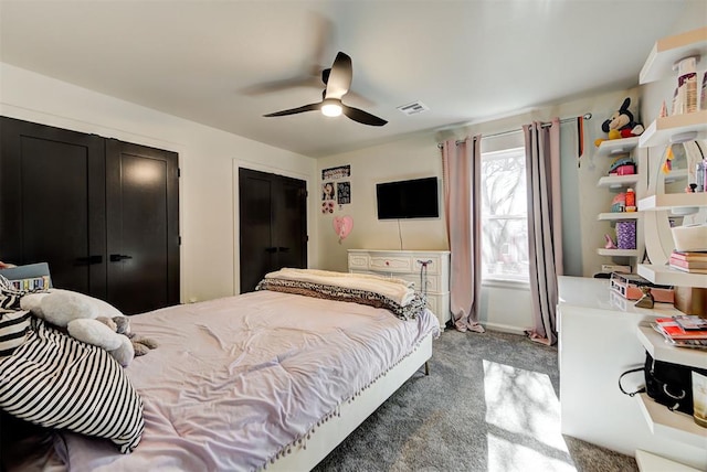 carpeted bedroom featuring multiple closets and ceiling fan