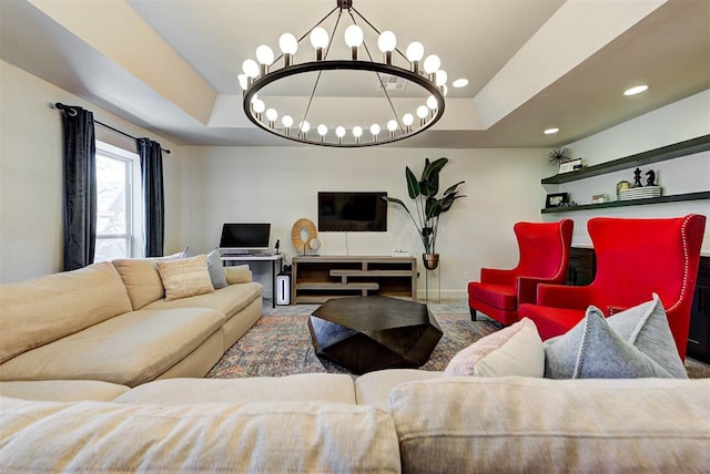 living room featuring a tray ceiling and a chandelier