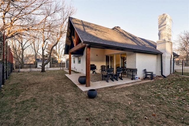 rear view of house featuring a patio area and a lawn