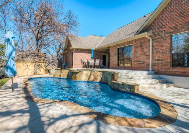 view of swimming pool featuring pool water feature and a patio area