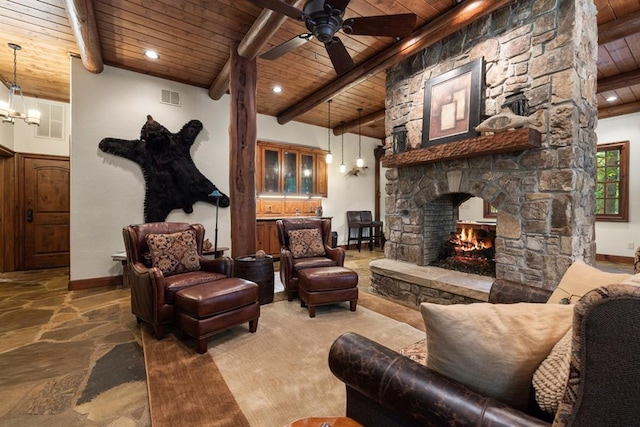 living room featuring wood ceiling, a fireplace, beamed ceiling, and ceiling fan with notable chandelier