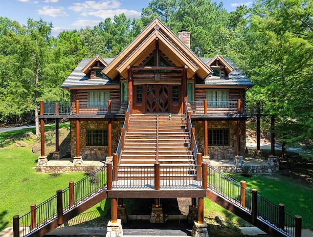 view of front of property featuring a wooden deck, a patio area, and a front lawn