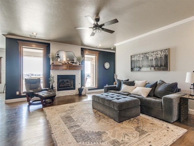 living room featuring dark hardwood / wood-style floors, ceiling fan, and ornamental molding