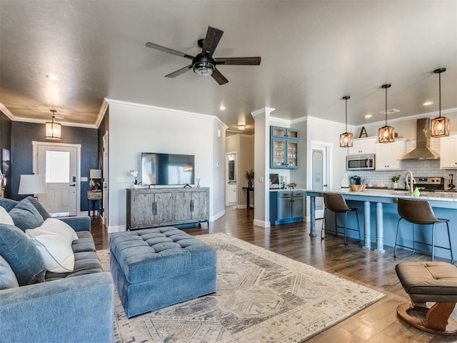 living room with sink, ceiling fan, crown molding, and dark hardwood / wood-style flooring