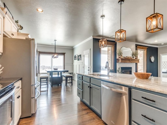 kitchen featuring sink, stainless steel appliances, gray cabinetry, and decorative light fixtures