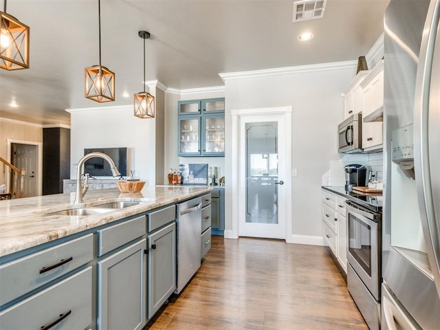 kitchen featuring sink, decorative light fixtures, white cabinetry, gray cabinetry, and stainless steel appliances