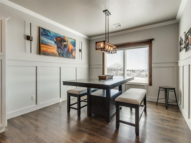 dining area featuring breakfast area, dark hardwood / wood-style floors, ornamental molding, and a chandelier