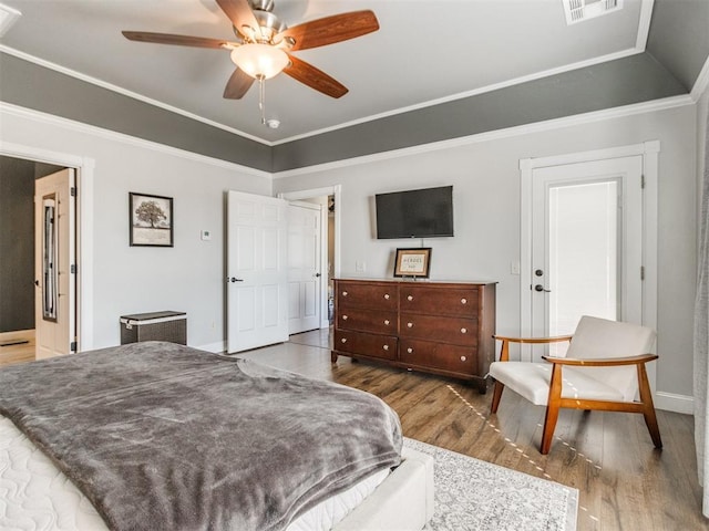 bedroom with ceiling fan, hardwood / wood-style flooring, ornamental molding, and lofted ceiling