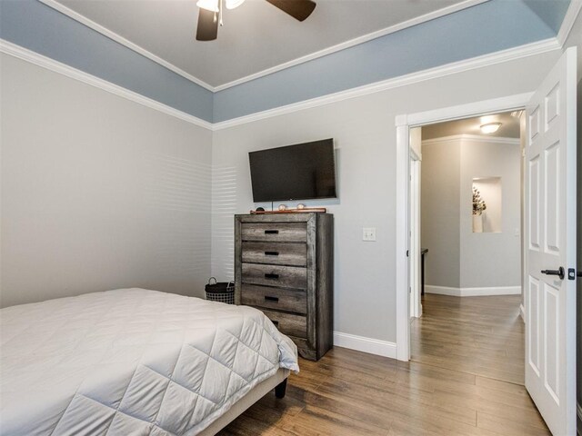 bedroom featuring ceiling fan, hardwood / wood-style flooring, and crown molding