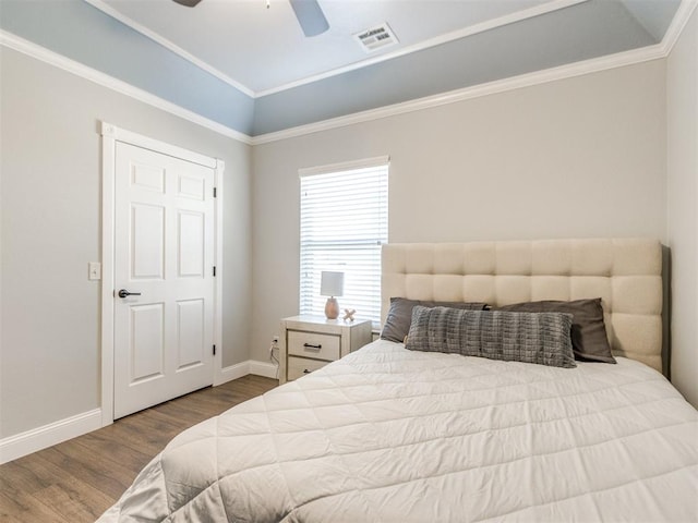 bedroom featuring crown molding, light hardwood / wood-style flooring, a tray ceiling, and ceiling fan