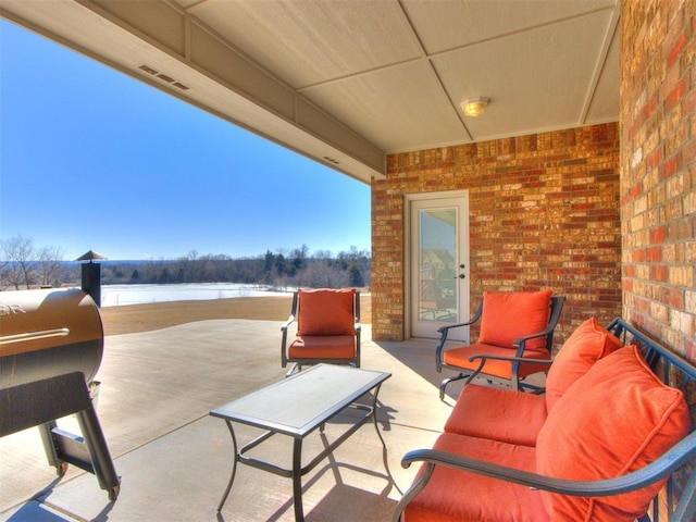 view of patio / terrace with a water view and a grill